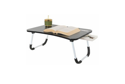 Meta Furniture Laptop Table With Lights And Drawer with black surface and white foldable legs holding an open book and a candle