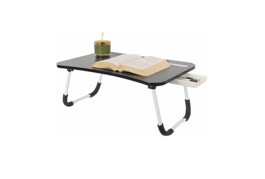 Meta Furniture Laptop Table With Lights And Drawer with black surface and white foldable legs holding an open book and a candle